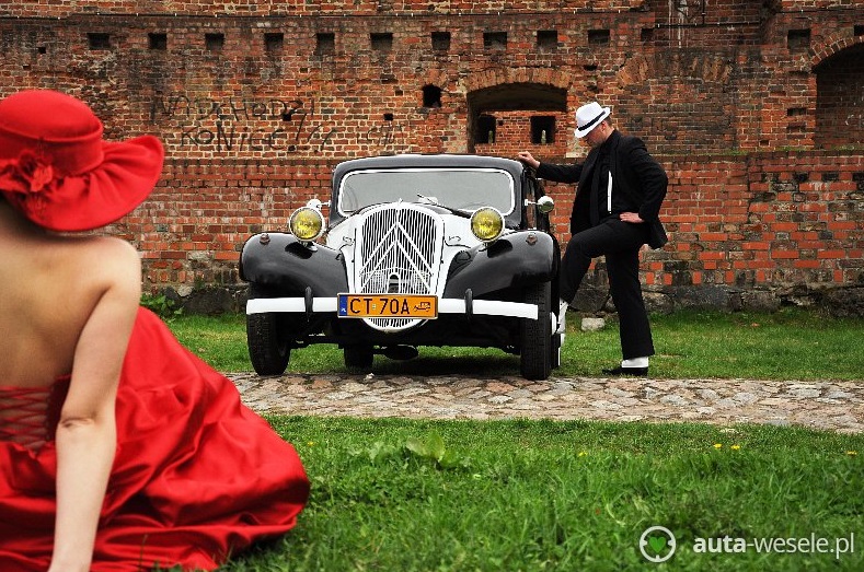 Młoda para - sesja ślubna przy murach z samochodem